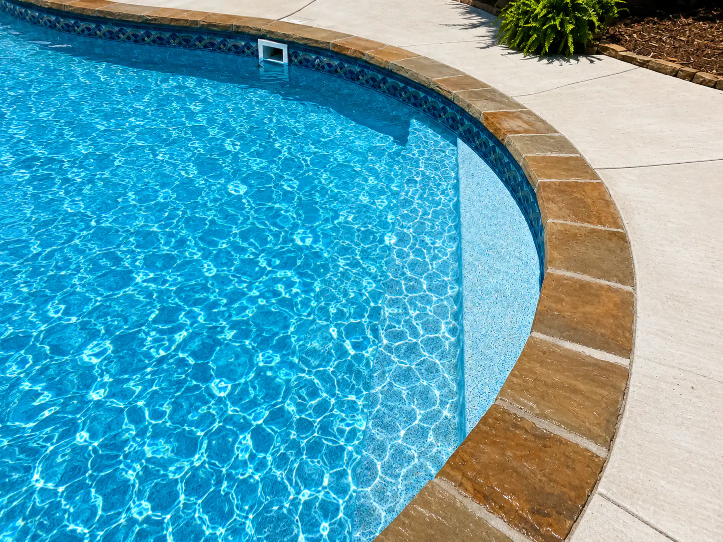 Close detail of vinyl liner and coping on an Arkansas inground pool